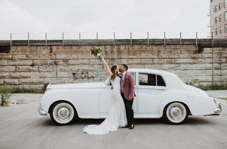 Couple celebrates and kisses in front of vintage car in Chicago